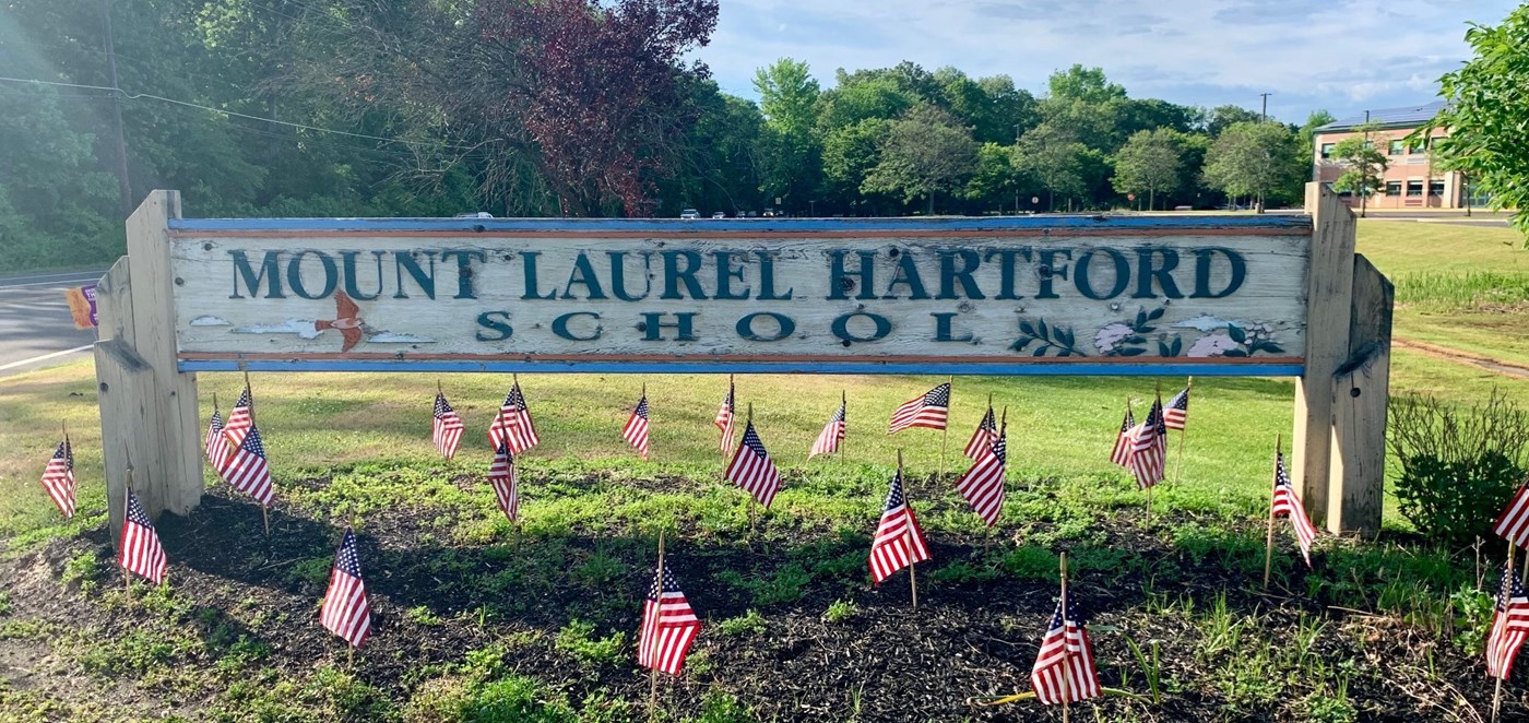 Hartford Sign with American Flags posted in the ground