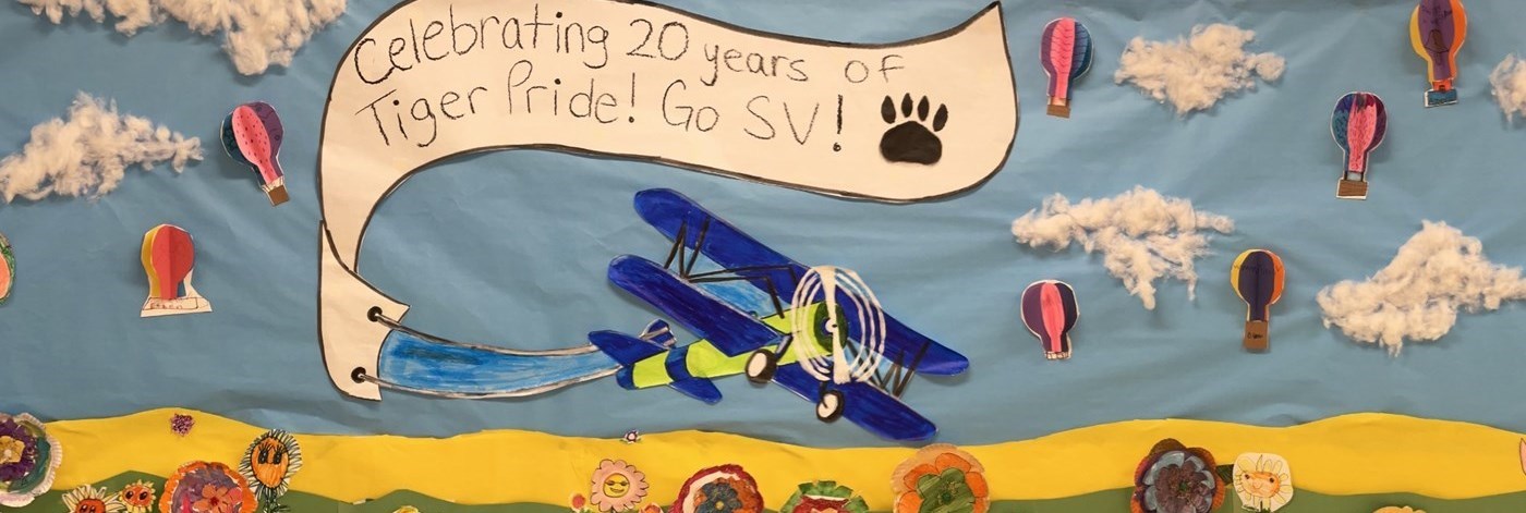 Spring Banner with Flowers and Hot air Balloons created by our Students and Becky Rosen Art Teacher -Banner with &#34;Celebrating 20 years of TigerPride! Go SV!&#34; written on a banner tailing the plane