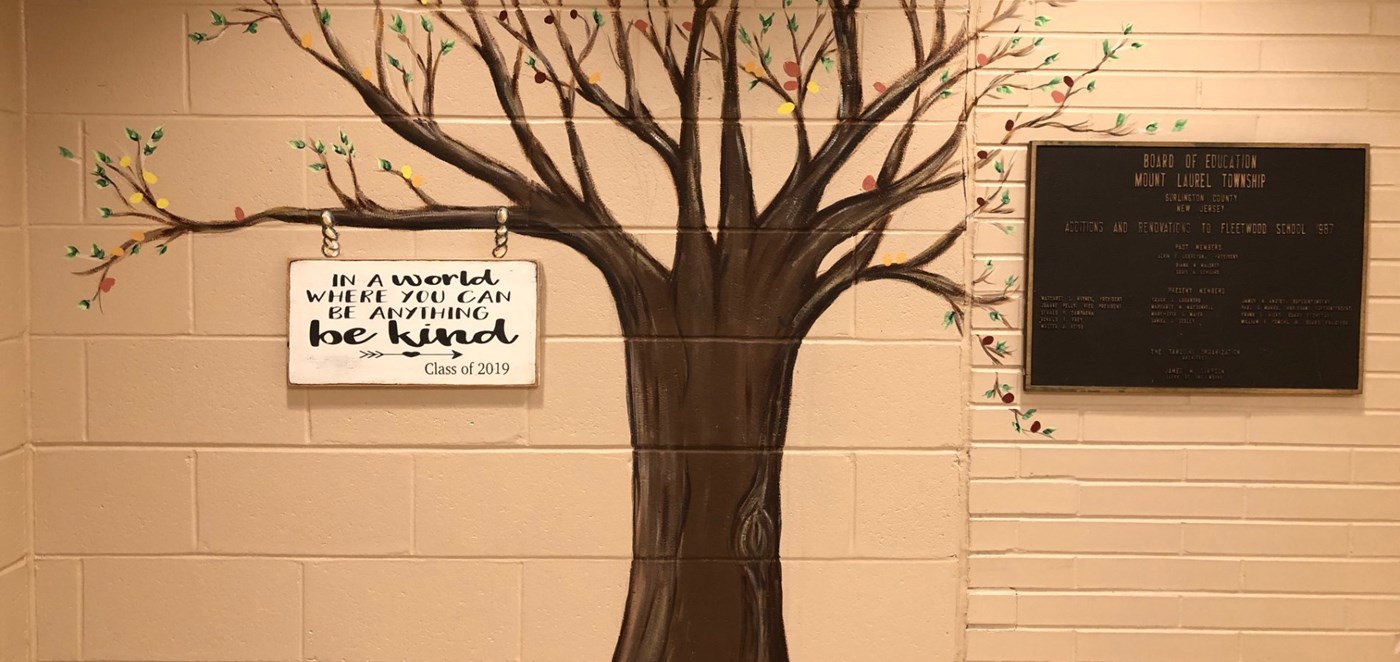Mural of a tree with sign handing - in a world whre you can be anything be kind - Class of 2019. Mount Laurel building Founding  plaque