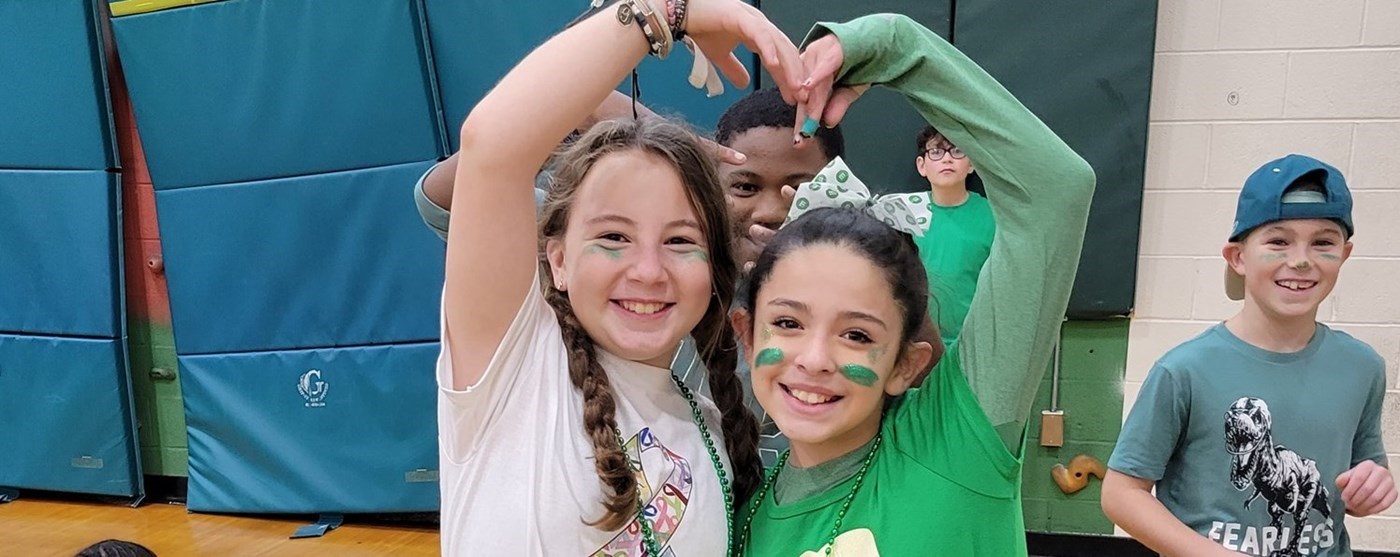 Two students from Ms. Loadenthal&#39;s class on Field Day making a heart with their arms