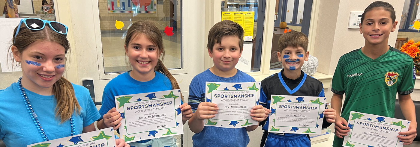 Students Holding Field Day Sportsmanship Certificates